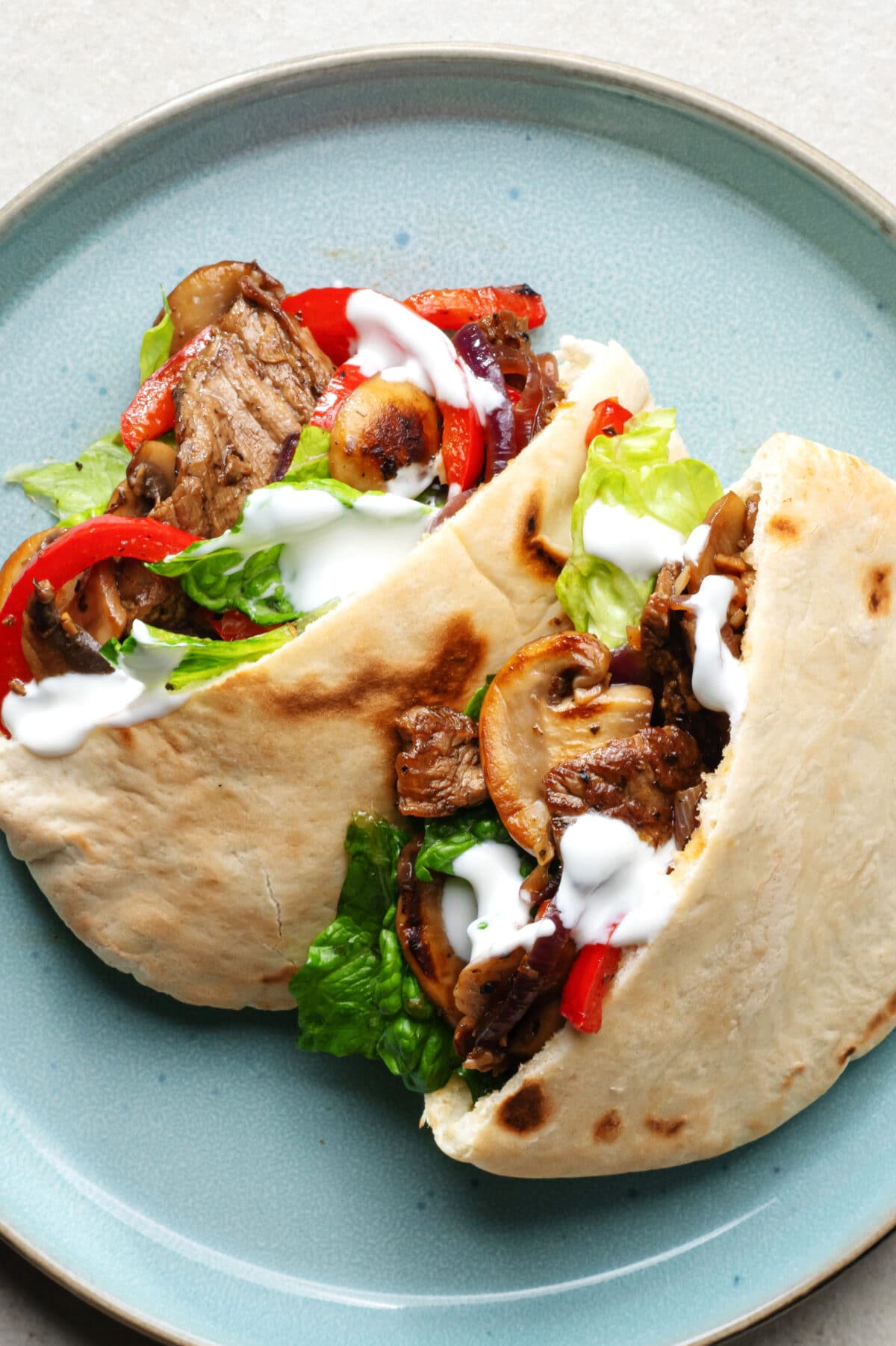 steak fajita sandwiches on a blue plate