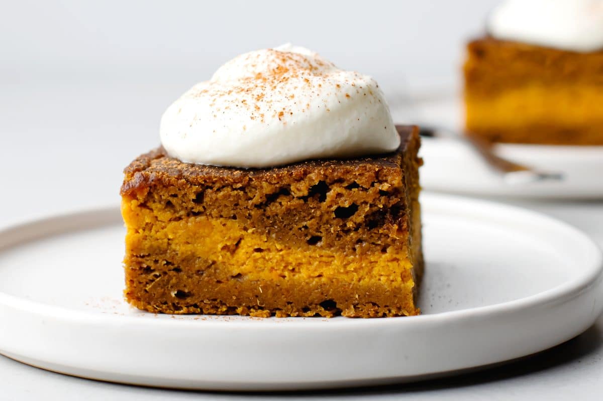 a piece of pumpkin spice latte cake with a dollop of cream on top and a sprinkle of pumpkin pie spice