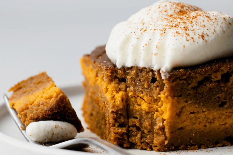 close up of a piece of slow cooker pumpkin spice cake on a plate with a bite missing out of it