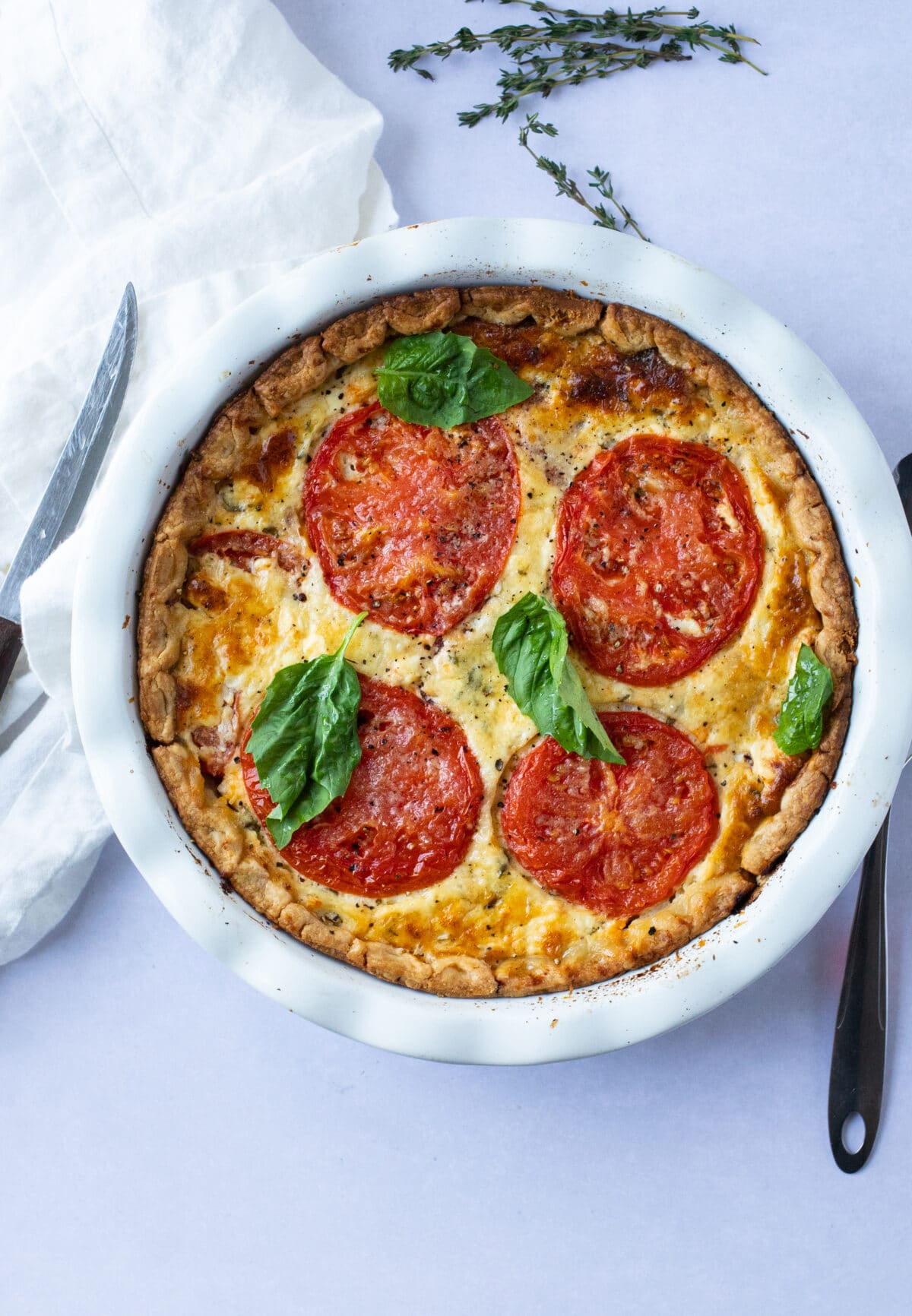 deep dish tomato pie in a white pie dish