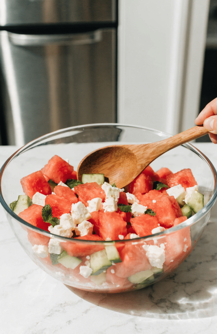 Hand stirring ingredients in a mixing bowl with a wooden spoon