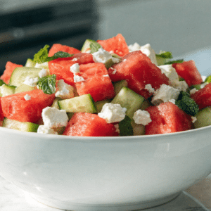 close up image of watermelon cucumber salad in a white serving bowl