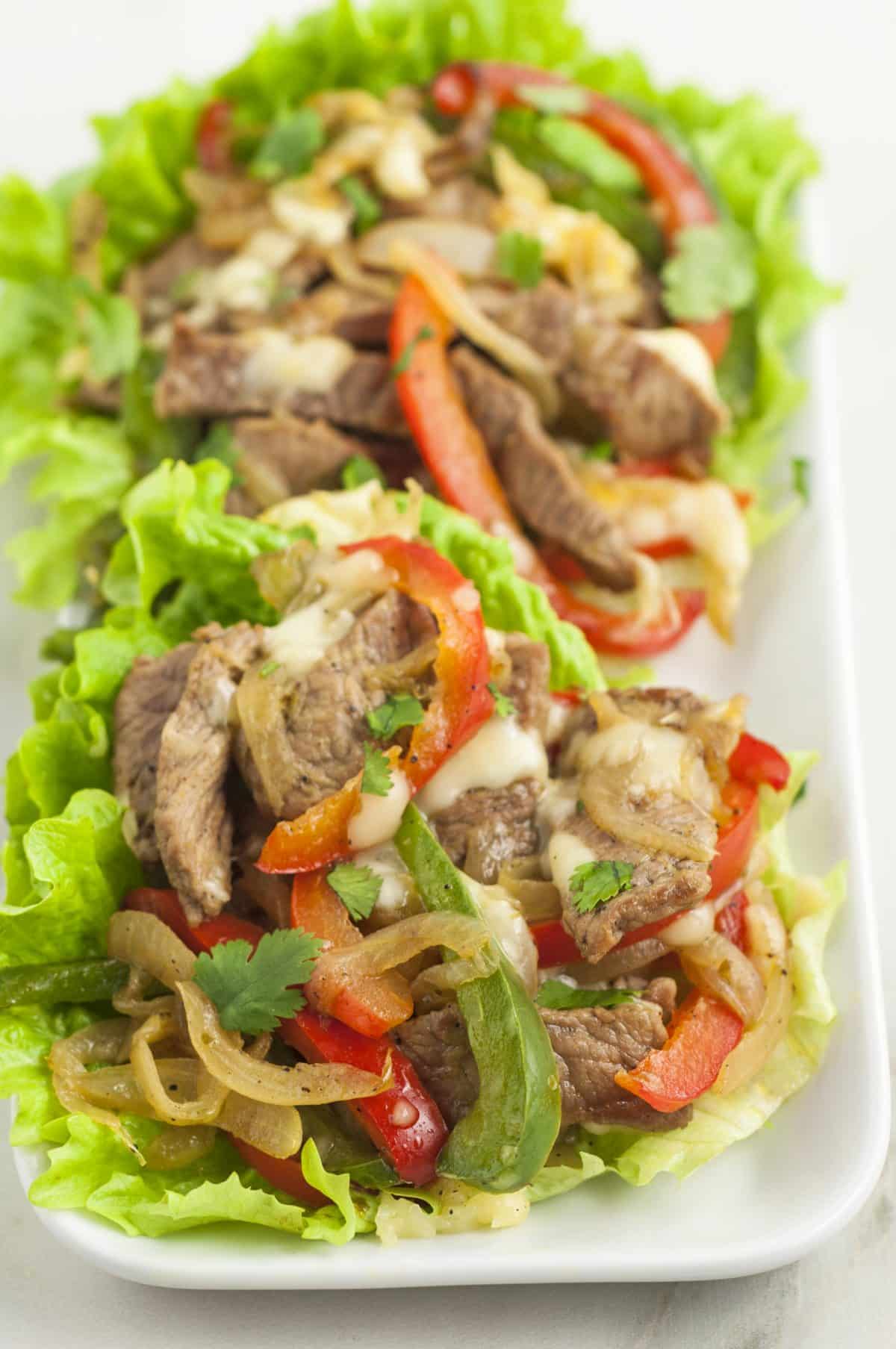 filled lettuce wraps on a long white platter