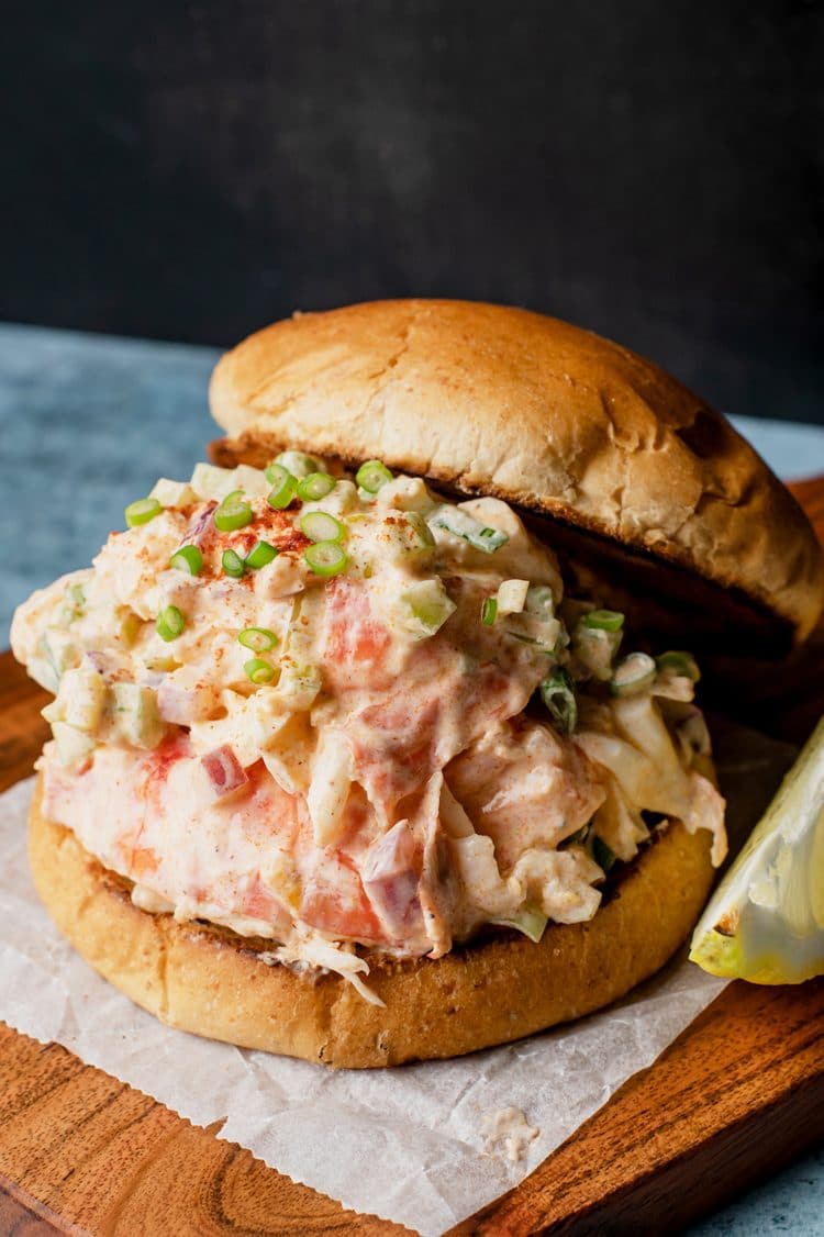 filled lobster roll without mayo from the top side view on a wooden plate