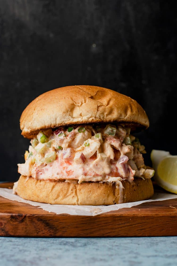 side view of lobster roll sandwich with lemon slice