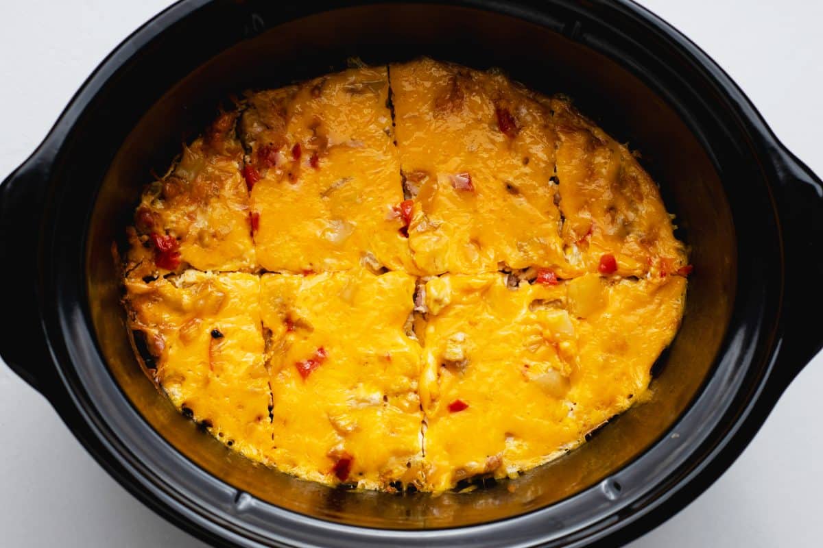 fully cooked breakfast casserole with peppers, onion, and turkey sausage in the corck pot sliced into 8 pieces.