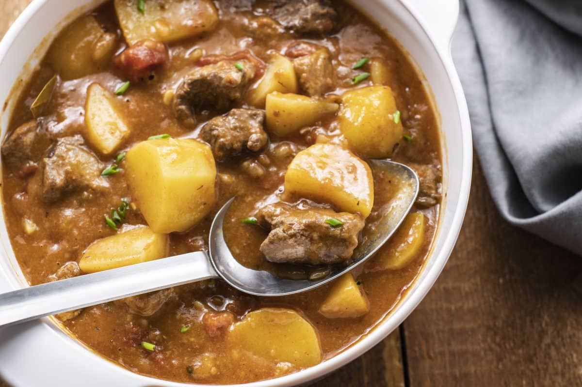 A slightly more zoomed out version of a spoon in the bowl with a napkin on the side