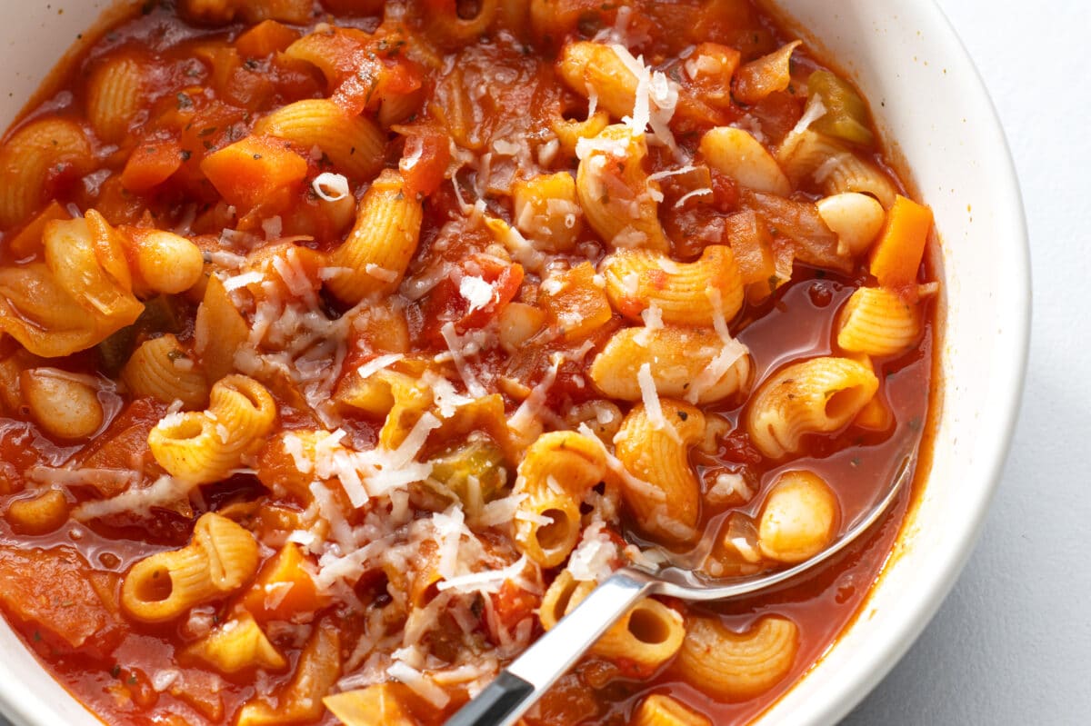 close up view of minestrone soup topped with fresh parmesan