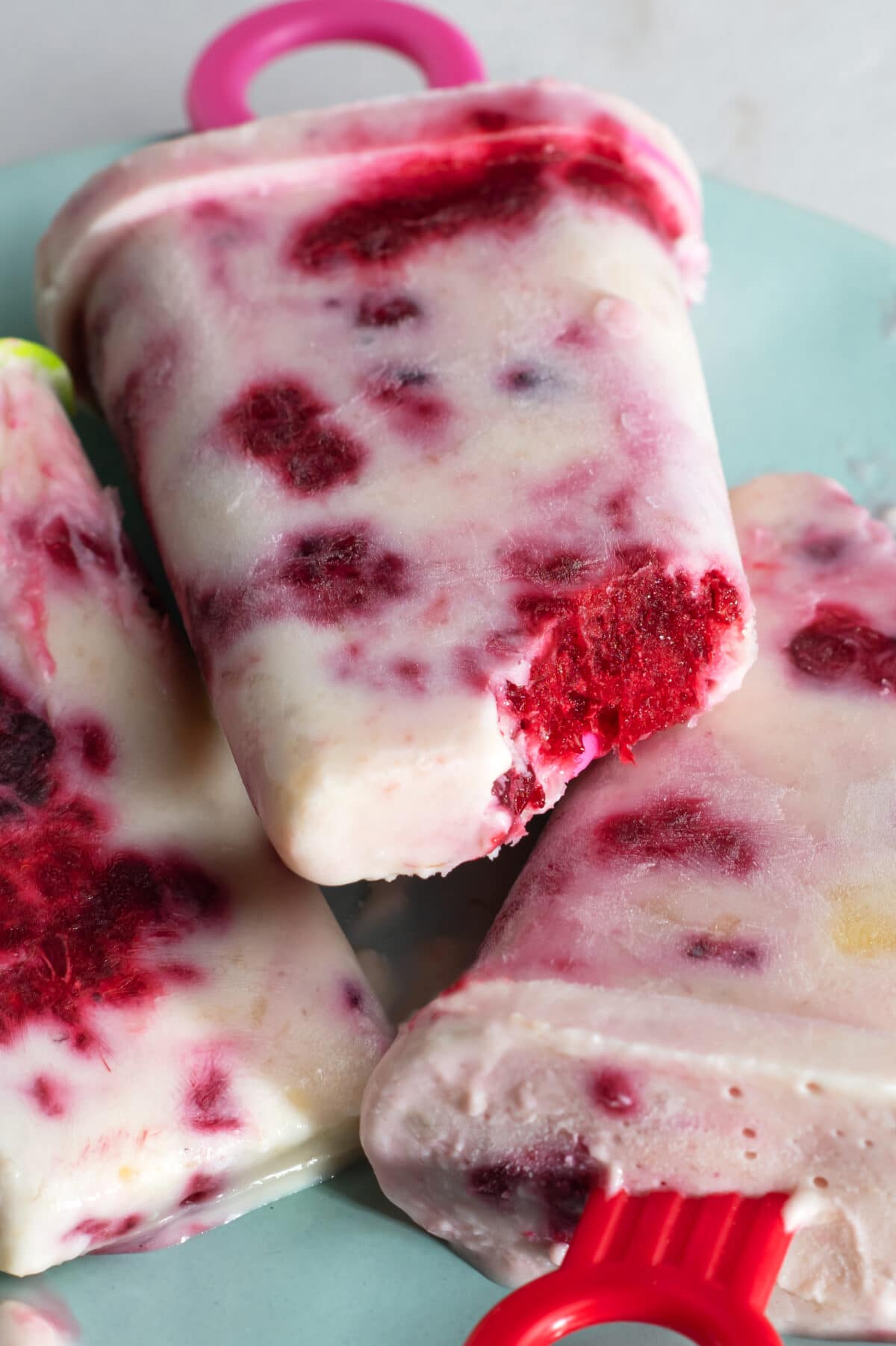 fruity frozen yogurt pops on blue plate
