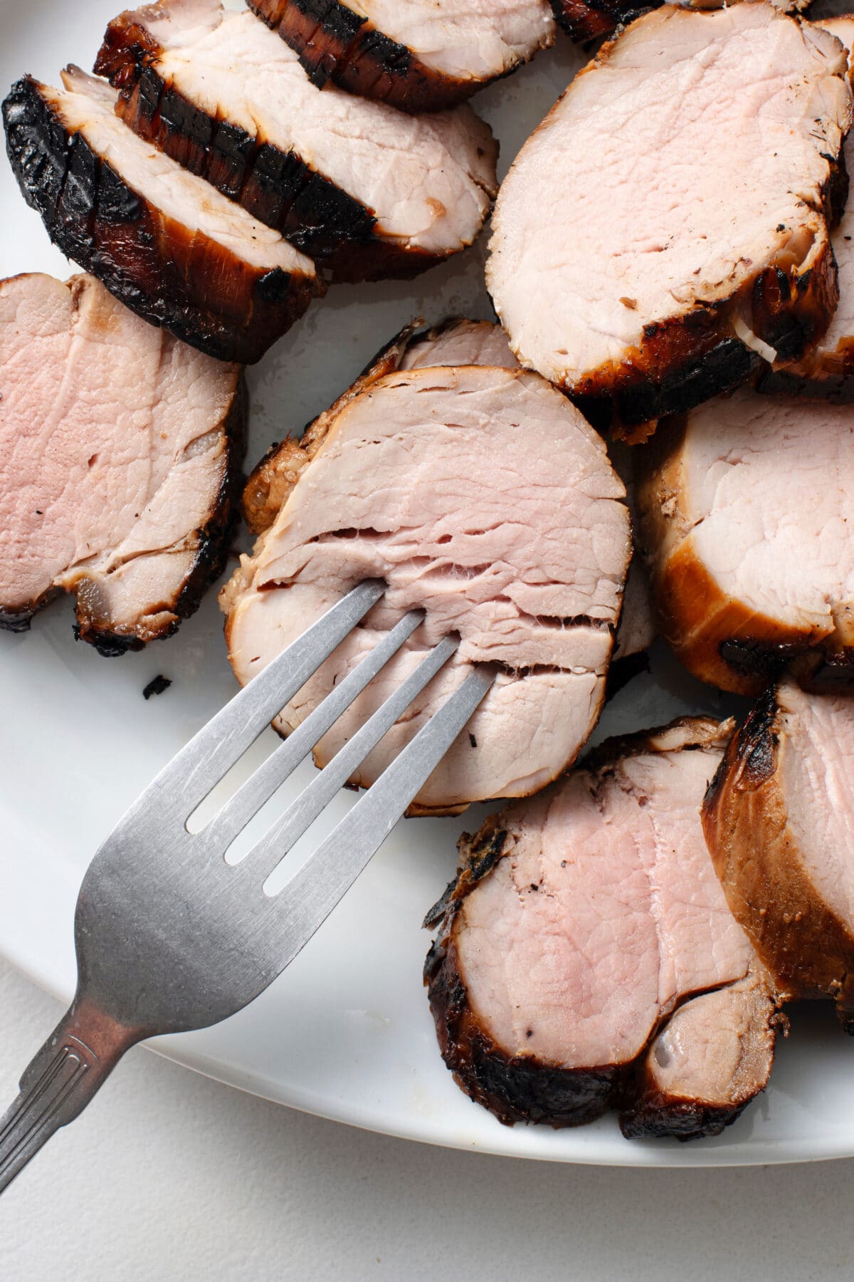 grilled bourbon pork tenderloin with a fork poking into it