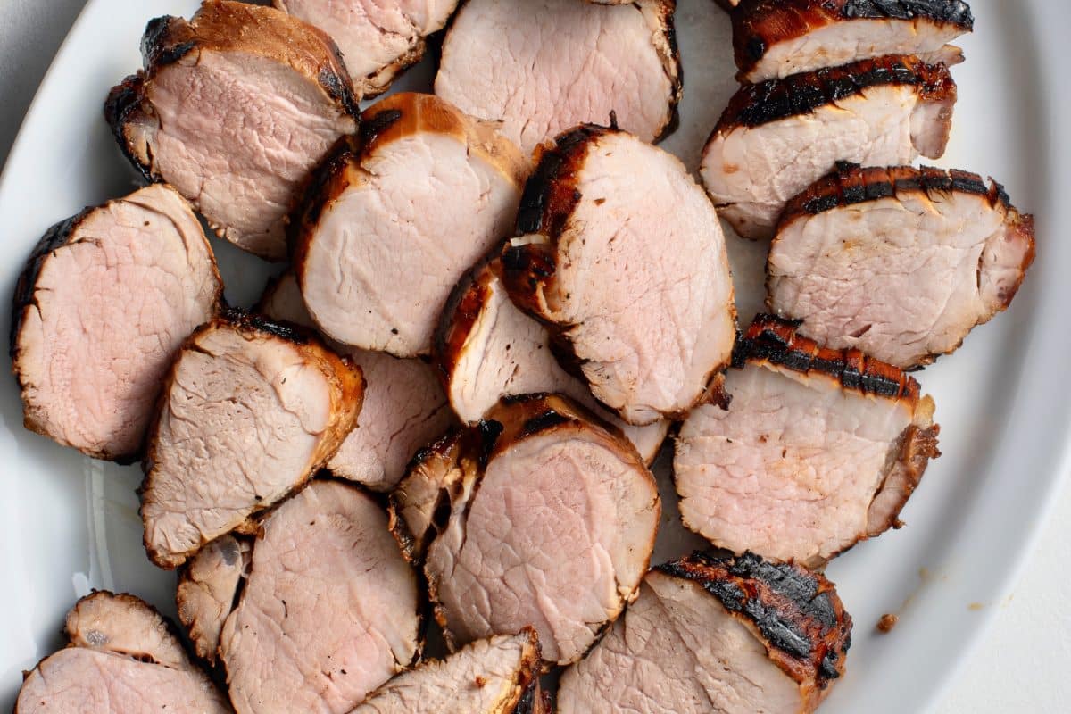 grilled bourbon sliced tenderloin arranged on white plate