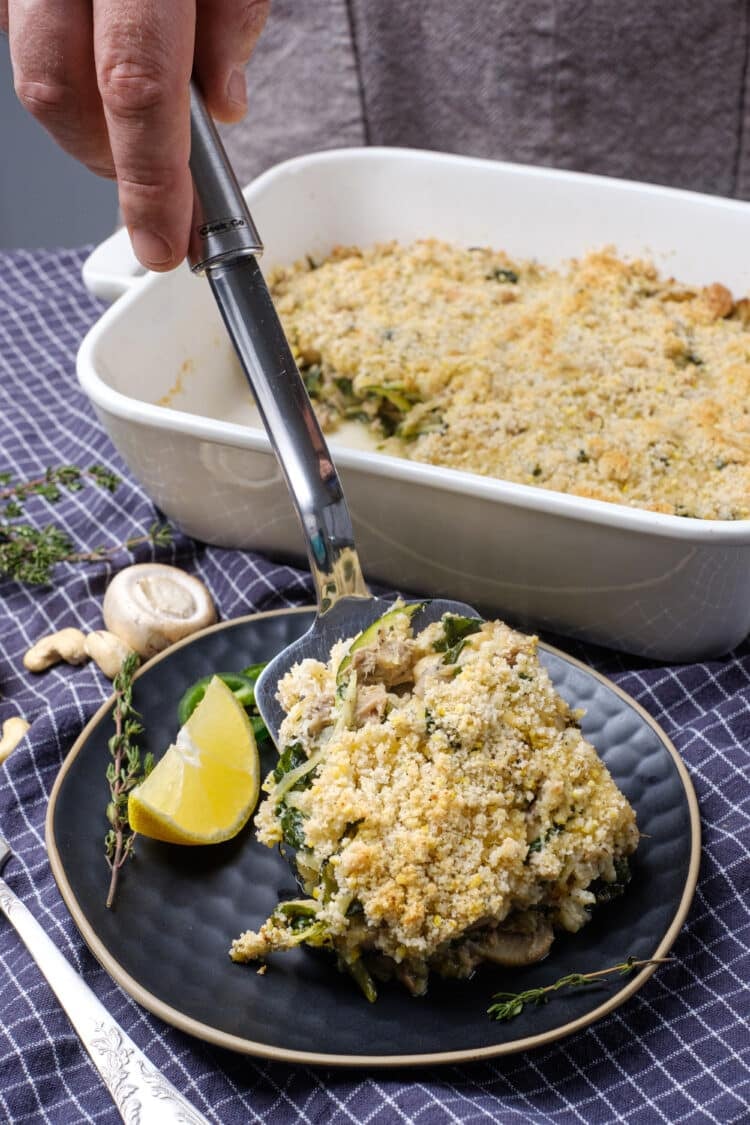 man scooping a serving out of a baking dish