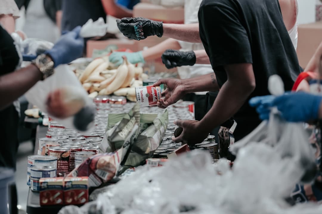 People working at a food bank handing out food with gloves on.