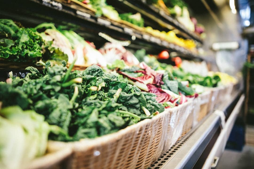 Row of vegetables placed on multilayered display fridge.