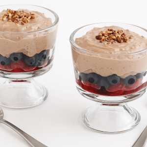 Two healthy breakfast sundaes with two spoons next to them