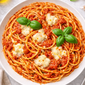 close up image of plated spaghetti with basil garnish