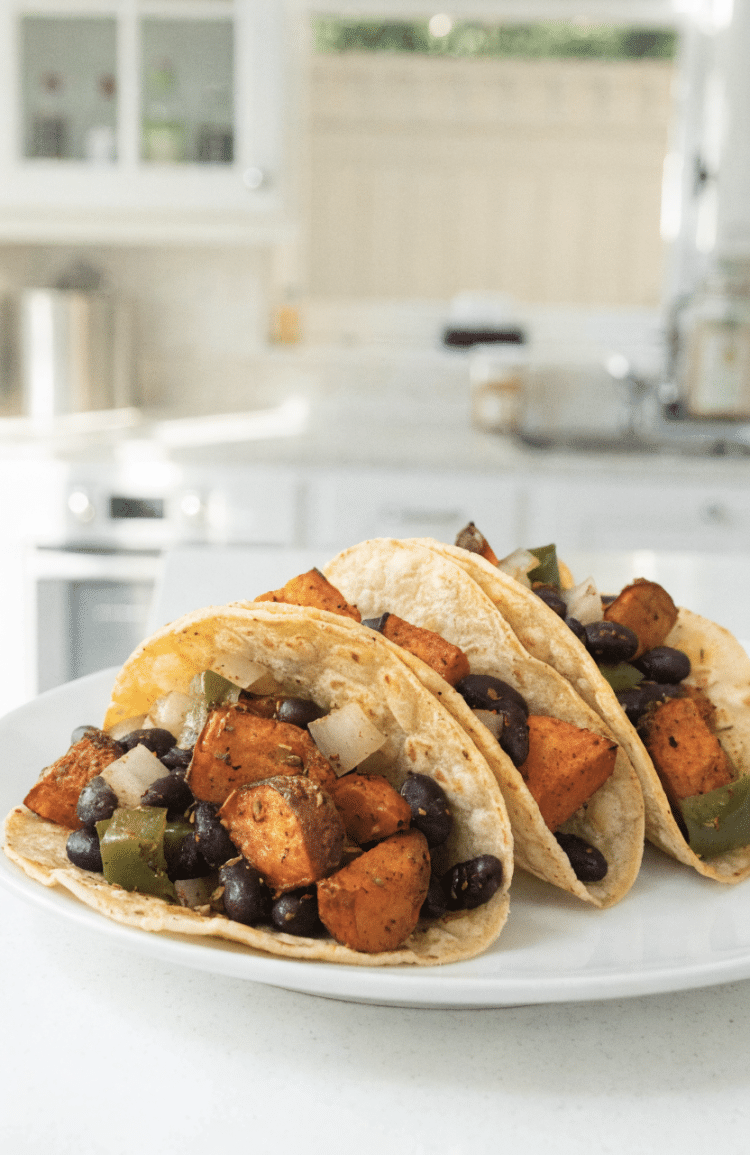 3 tacos on a plate in a white kitchen